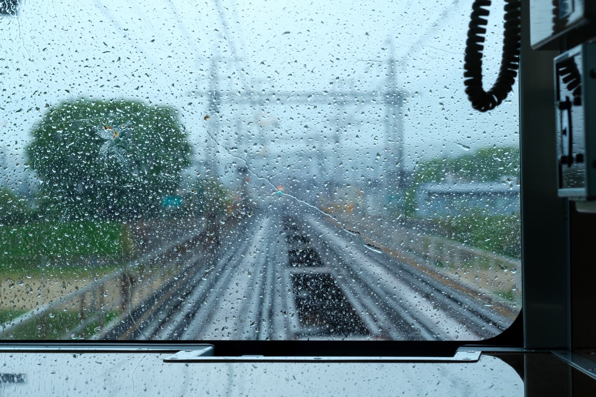 電車の中から雨がついた窓を撮影